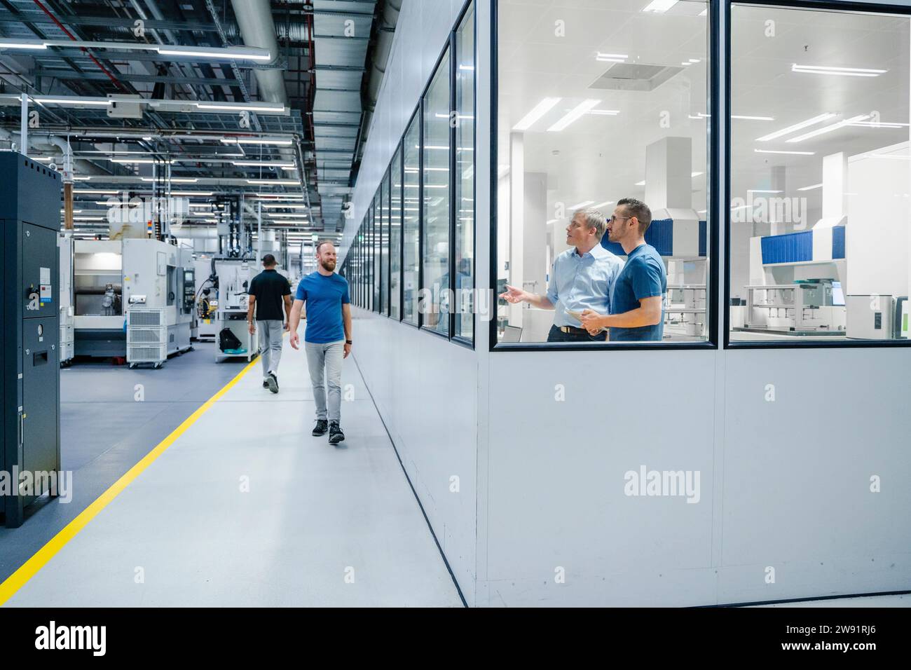 Homme d'affaires et employés dans une usine Banque D'Images