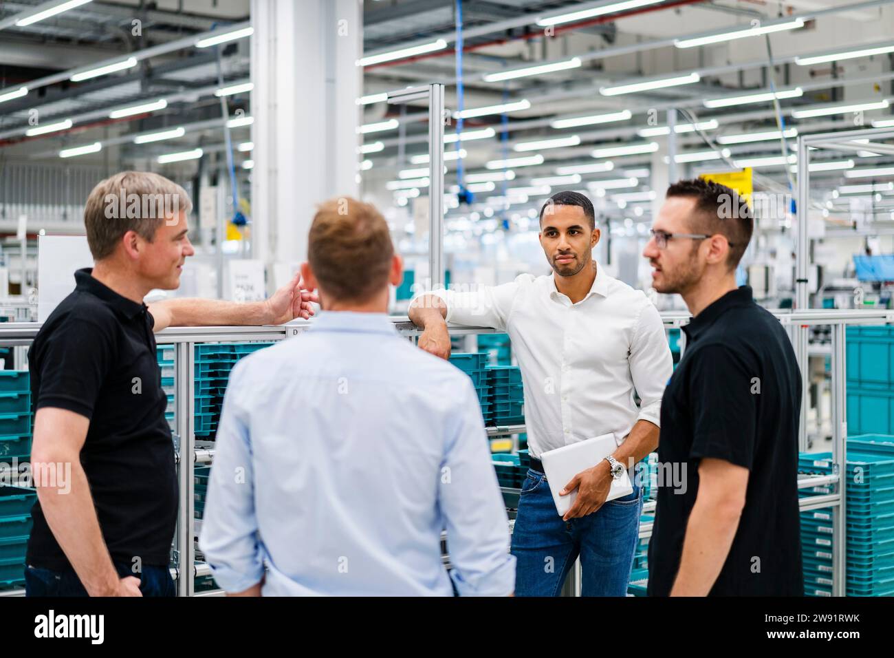 Hommes d'affaires et employés ayant une réunion dans une usine Banque D'Images