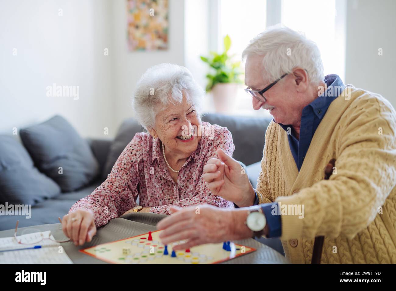 Heureux couple senior jouant au jeu de société ludo à la maison Banque D'Images