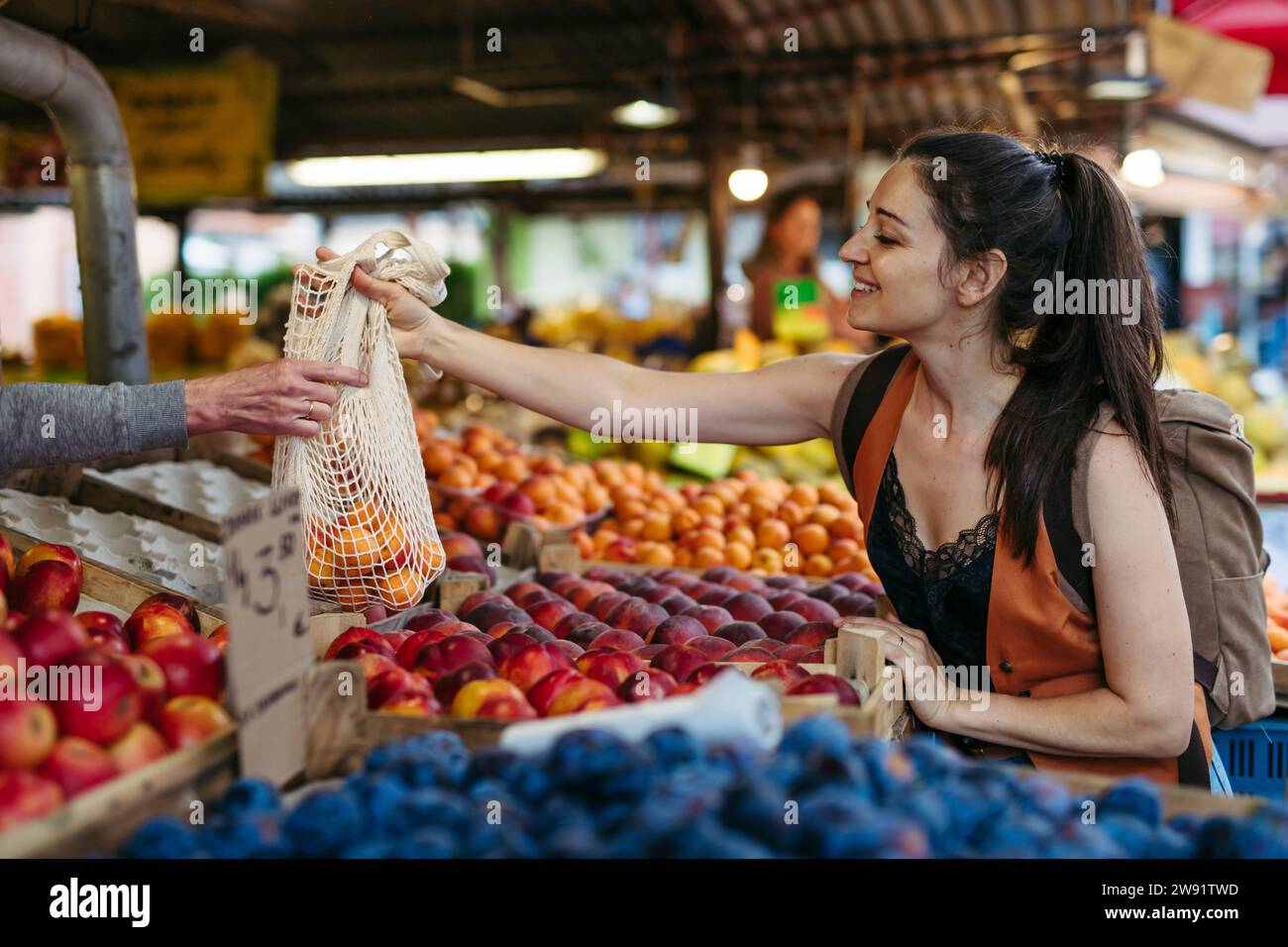 Femme magasinant des fruits et légumes frais au marché de la ville Banque D'Images