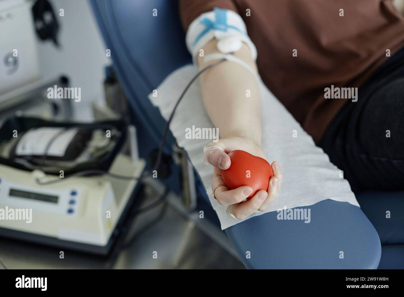 Main d'une femme tenant une balle molle donnant du sang Banque D'Images