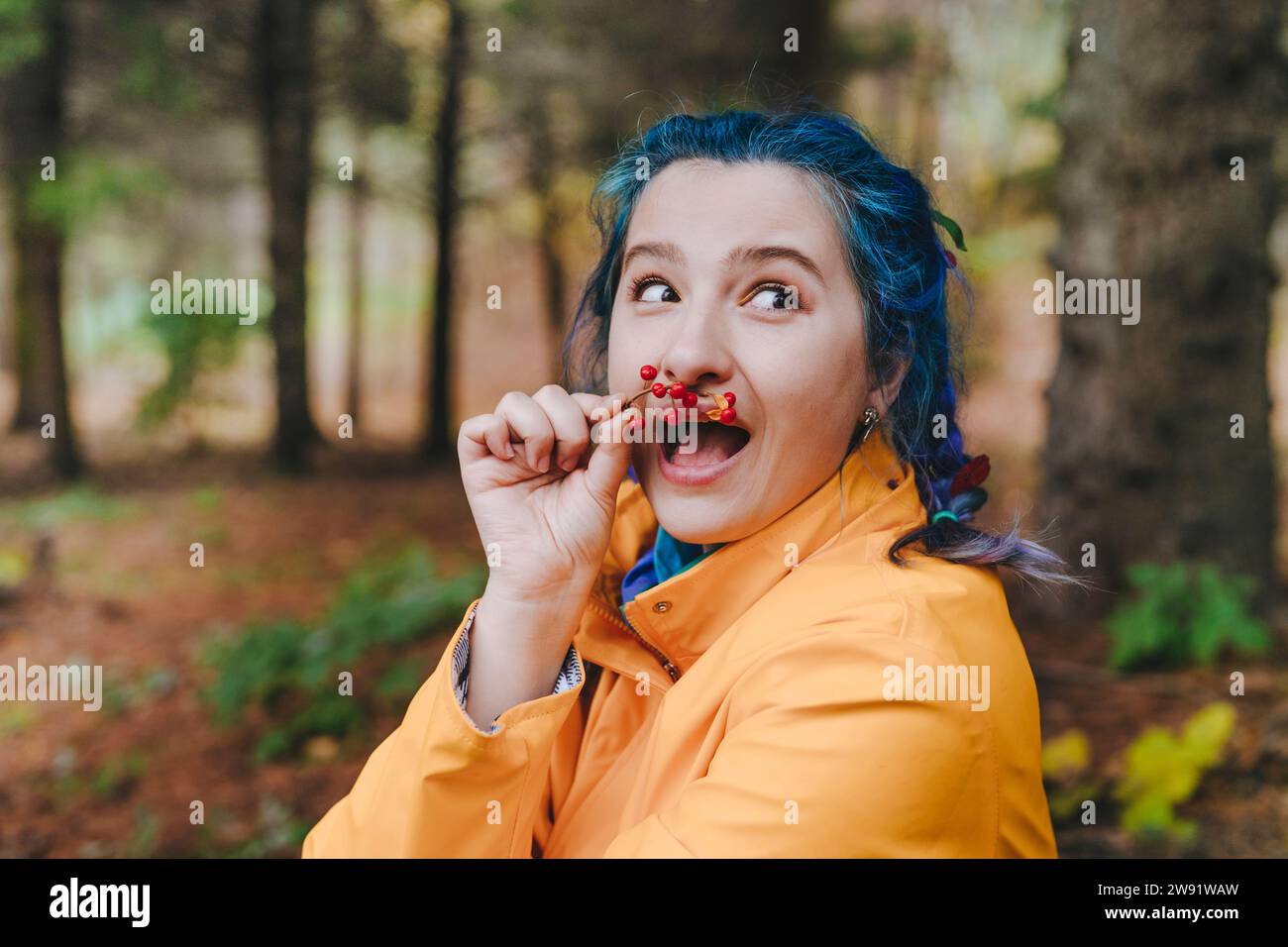 Femme surprise sentant les baies dans la forêt Banque D'Images