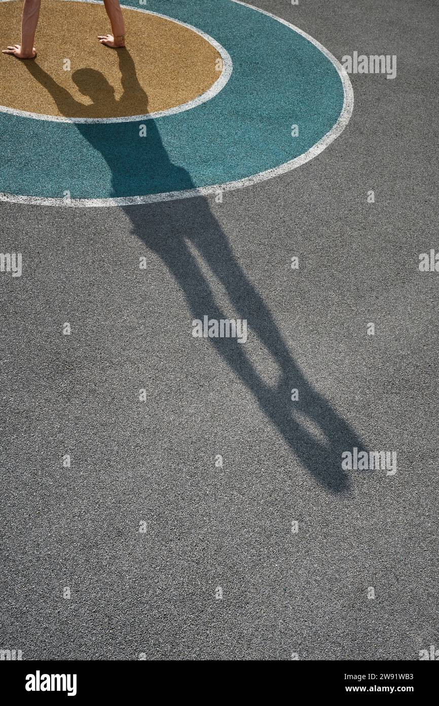 Ombre d'un homme faisant la main debout sur un terrain de sport Banque D'Images