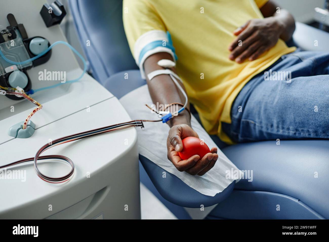 Homme tenant une balle molle et donnant du sang au centre Banque D'Images