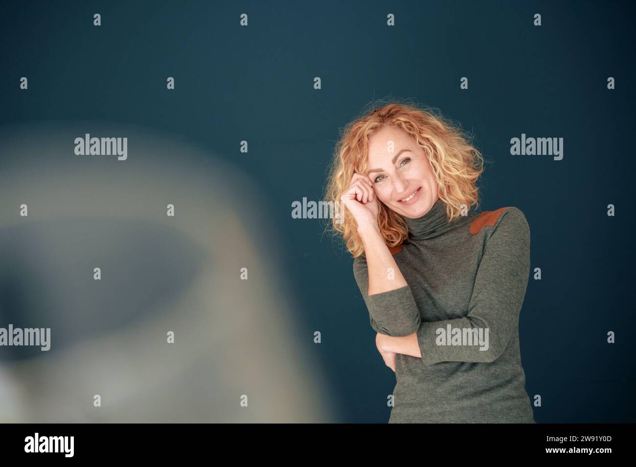 Femme souriante debout devant le mur Banque D'Images