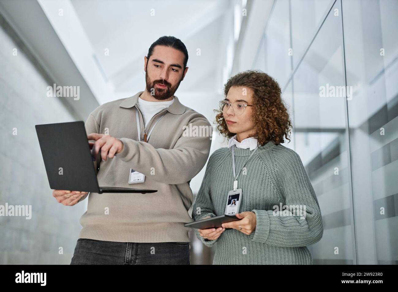 Ingénieur discutant du travail sur ordinateur portable avec un collègue au bureau Banque D'Images