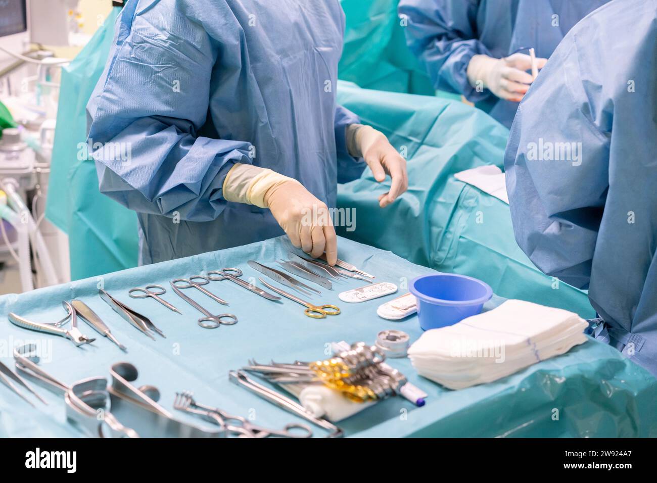 Infirmière tenant l'outil chirurgical avec les chirurgiens pratiquant l'intervention sur le patient aux urgences Banque D'Images