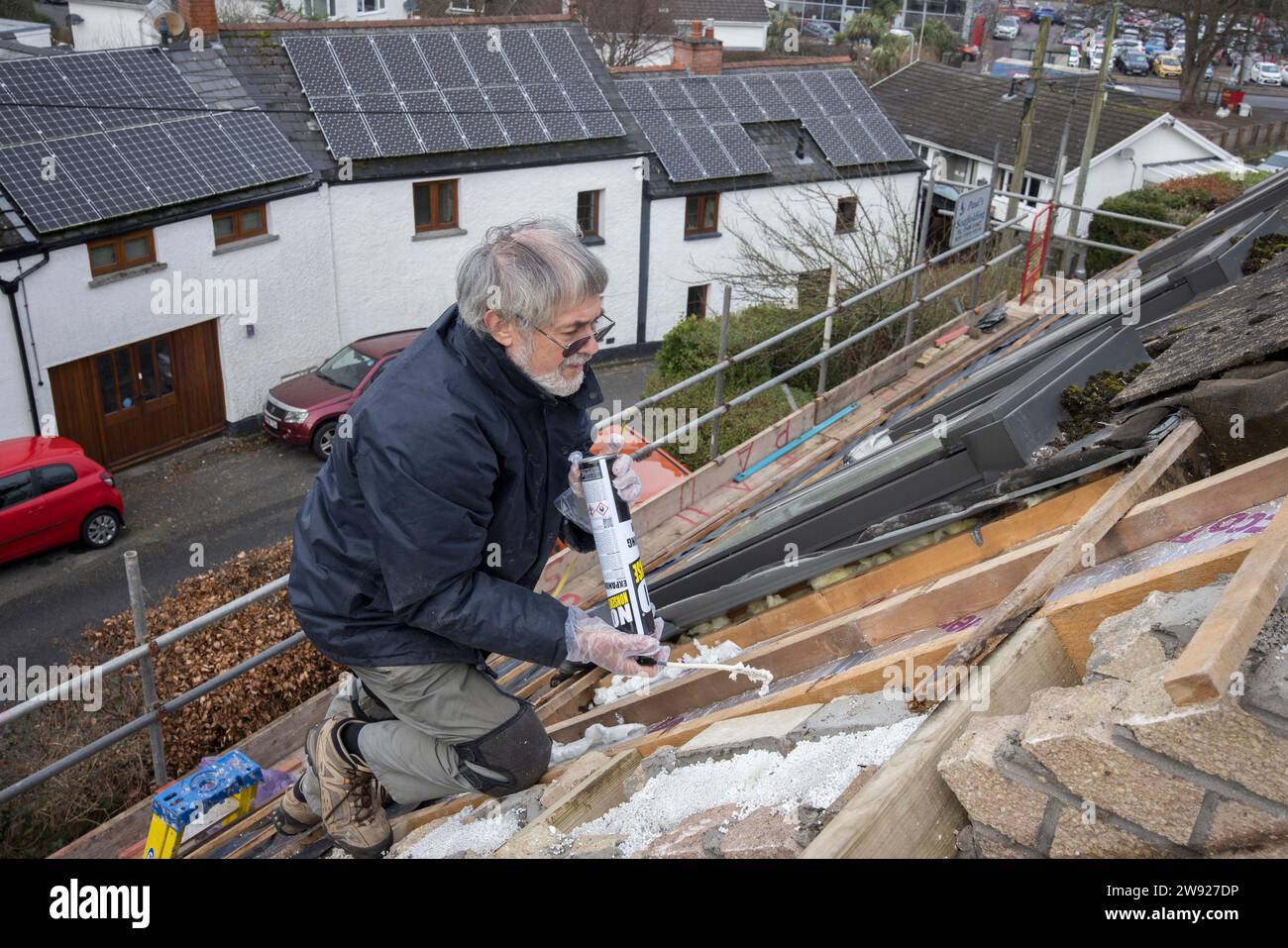 Scellage de panneaux isolants avec de la mousse expansée lors du remplacement d'un toit sur une maison domestique, pays de Galles, Royaume-Uni Banque D'Images