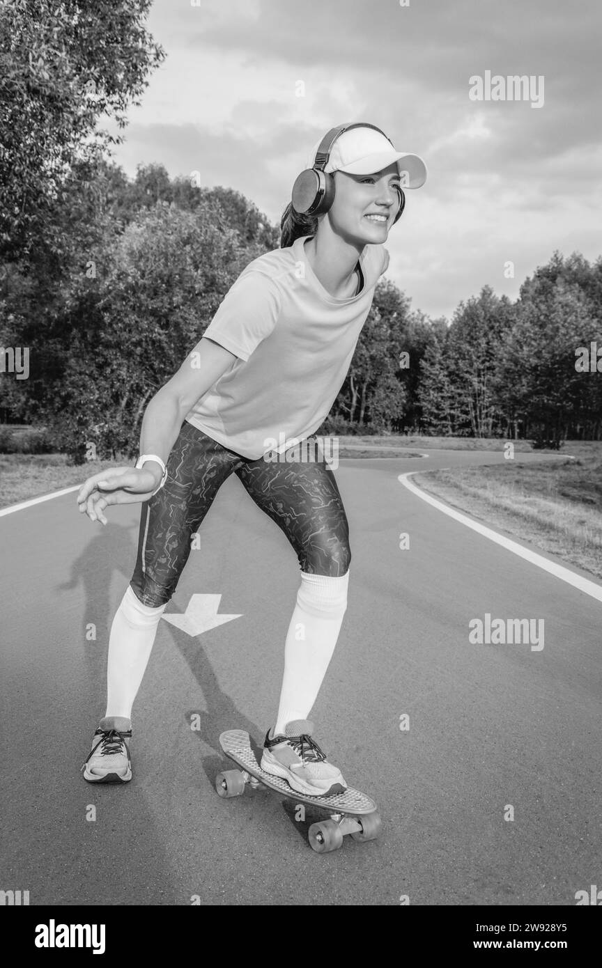 Image d'une fille chevauchant un skateboard dans le parc. Concept sportif. Supports mixtes Banque D'Images