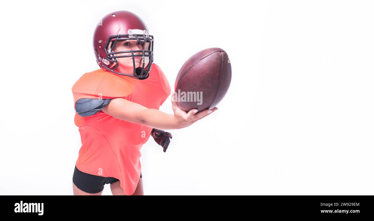 Femme dans l'uniforme d'un joueur d'équipe de football américain lance le ballon. Concept sportif. Supports mixtes Banque D'Images