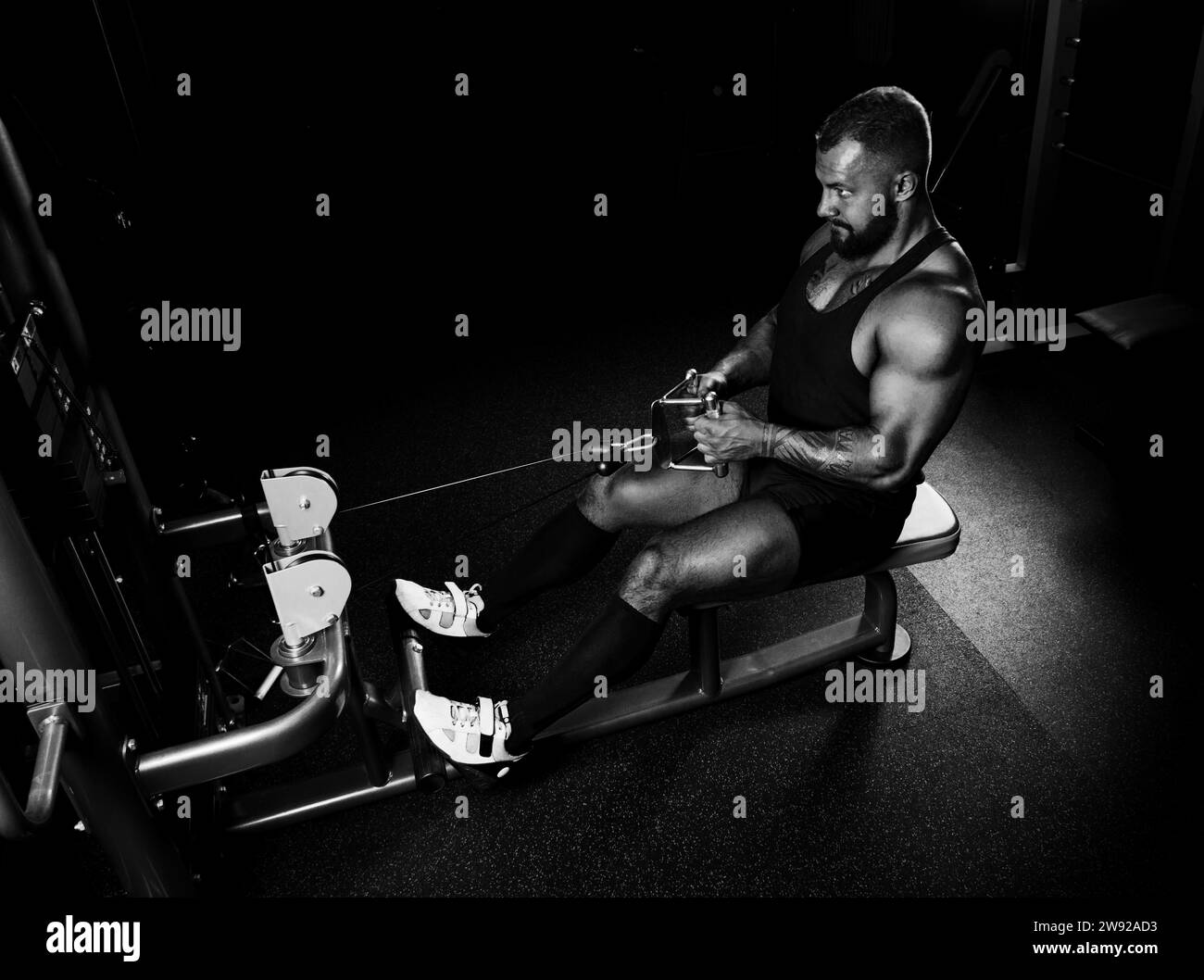 L'athlète effectue un exercice sur les muscles latissimus du dos sur un dispositif spécial. Vue latérale Banque D'Images
