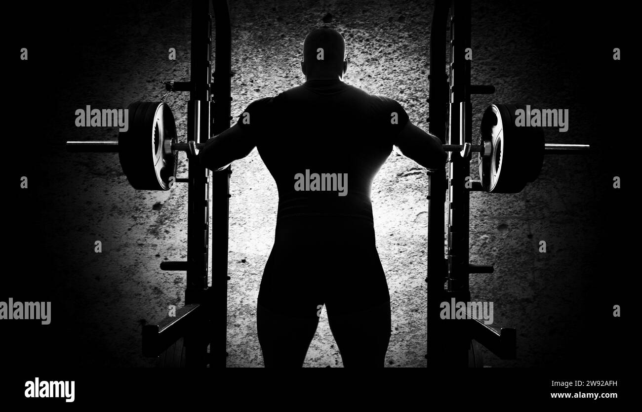 L'haltérophile se tient les mains derrière la lourde barre. Vue arrière Banque D'Images