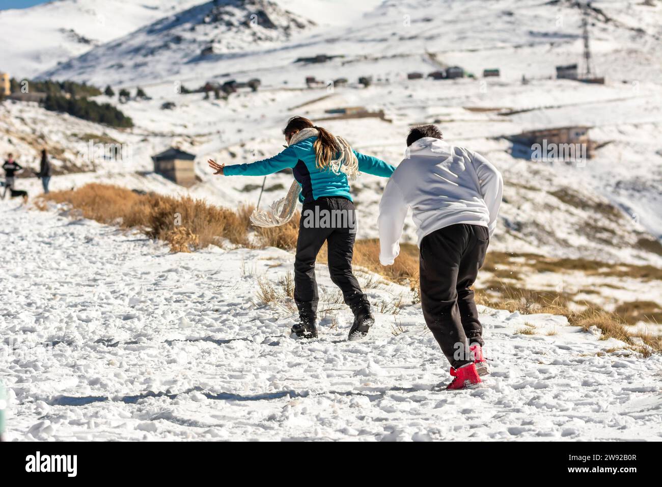 Des aventures glacées vous attendent ! Une famille latino se délecte dans les collines enneigées de la Sierra Nevada, Grenade, se livrant au plaisir glacial Banque D'Images