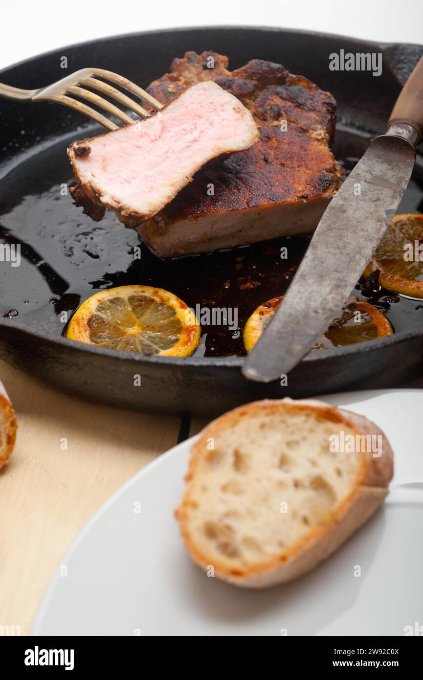 Côtelette de porc saisie sur poêle en fer avec assaisonnement au citron et aux épices, Photographie alimentaire, Photographie alimentaire Banque D'Images