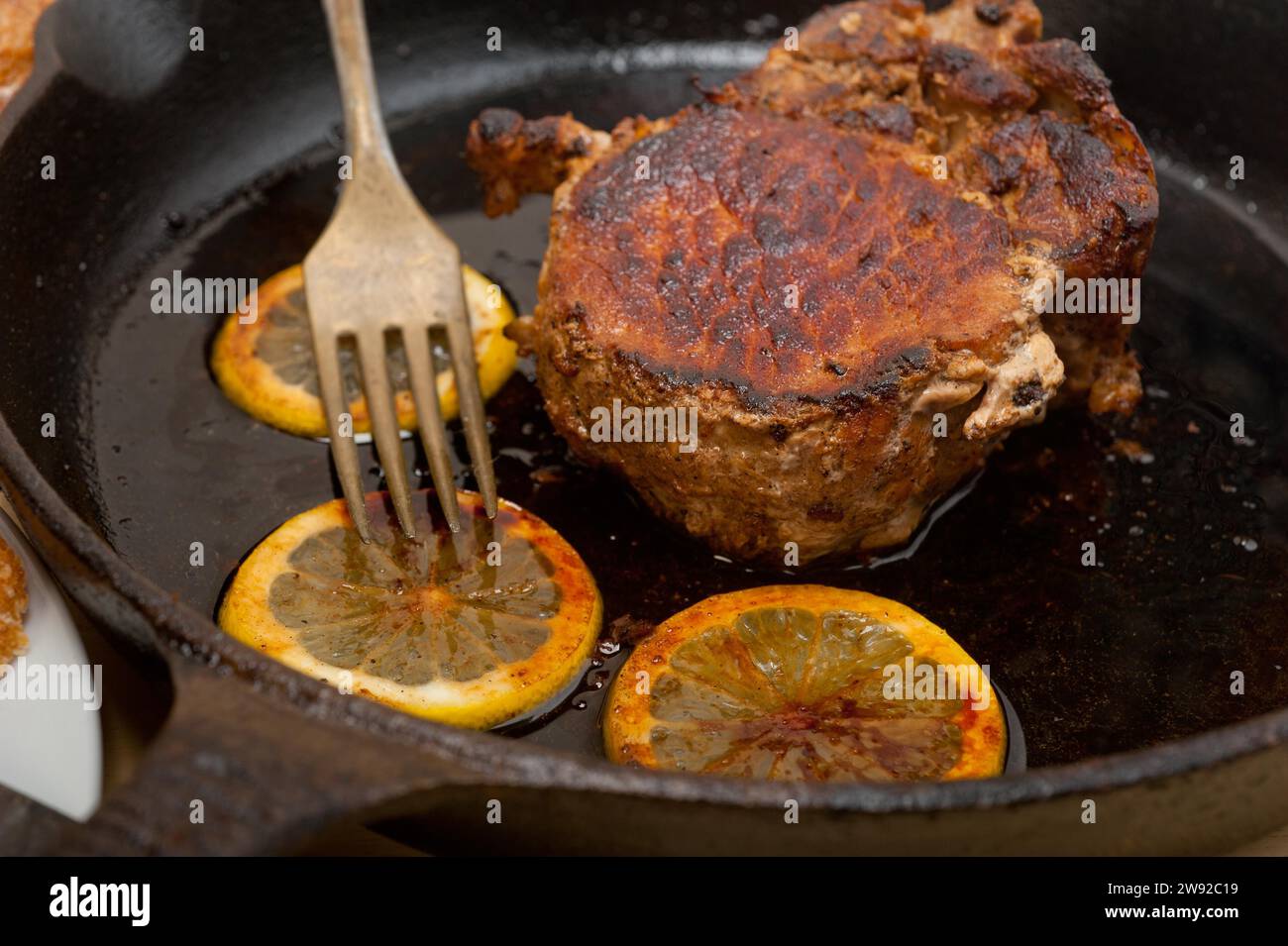 Côtelette de porc saisie sur poêle en fer avec assaisonnement au citron et aux épices, Photographie alimentaire, Photographie alimentaire Banque D'Images