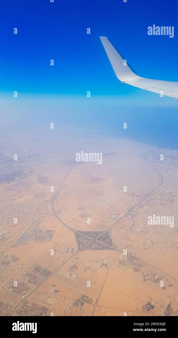 Vue de la fenêtre de l'avion sur le ciel bleu et la terre avec paysage de désert, mer et canaux dans les Émirats. Photo de haute qualité Banque D'Images