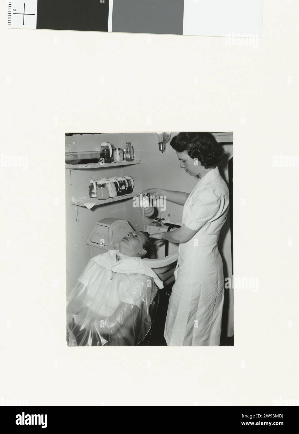 Fanny est étirée en chaise pour se laver les cheveux, 1949 photographies documentaires Fanny Blankers-Koen subit un soin de beauté dans 'House of Westmore', un salon de beauté à Hollywood. Tout d'abord, ses cheveux sont lavés par une esthéticienne. La série 'Fanny in America' contient six photos. Hollywood soutien photographique Hollywood Banque D'Images