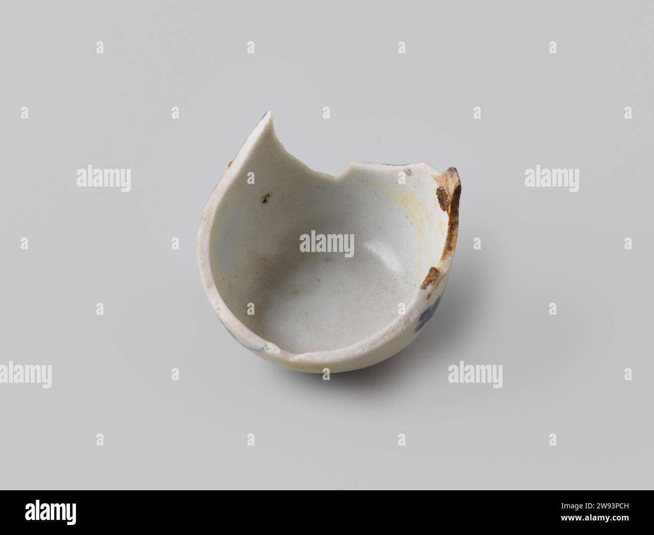 Fragment Wijnkom de V.O.C. navire de 'Witte Leeuw', avant 1613 fragment wijnkom. Au centre de cette vinecup sont tracées une fine ligne et une petite tache. À l'intérieur, un rouleau de fleurs et de tiges stylisées est dessiné. Autour de la lèvre-jante est une bande unique et autour du pied une double bande. Porcelaine Sint-Helena Banque D'Images