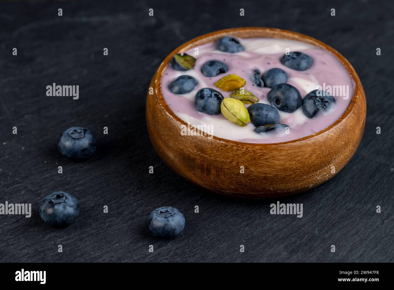 yogourt violet et blanc frais avec des myrtilles et une saveur de myrtille, délicieux yogourt frais à base de lait avec des myrtilles mûres Banque D'Images