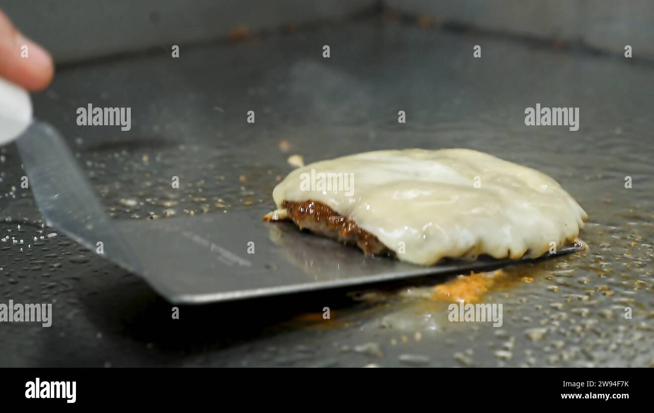 Hamburger salé appétissant recouvert de fromage fondu Banque D'Images