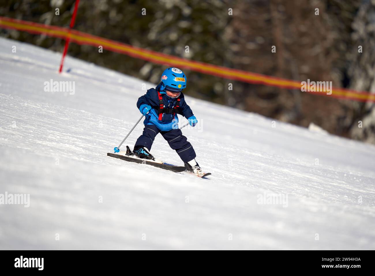 Feldberg, Allemagne - 08 février 2023 : débutant en ski pratiquant le ski alpin sur la neige. Petit garçon apprenant les sports d'hiver à l'école de ski. Parcours de ski Banque D'Images