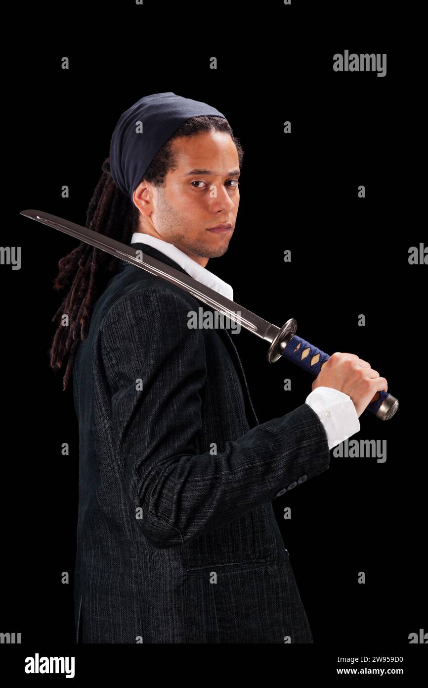 Jeune guerrier tenant une épée ninja (isolé sur fond noir) Banque D'Images