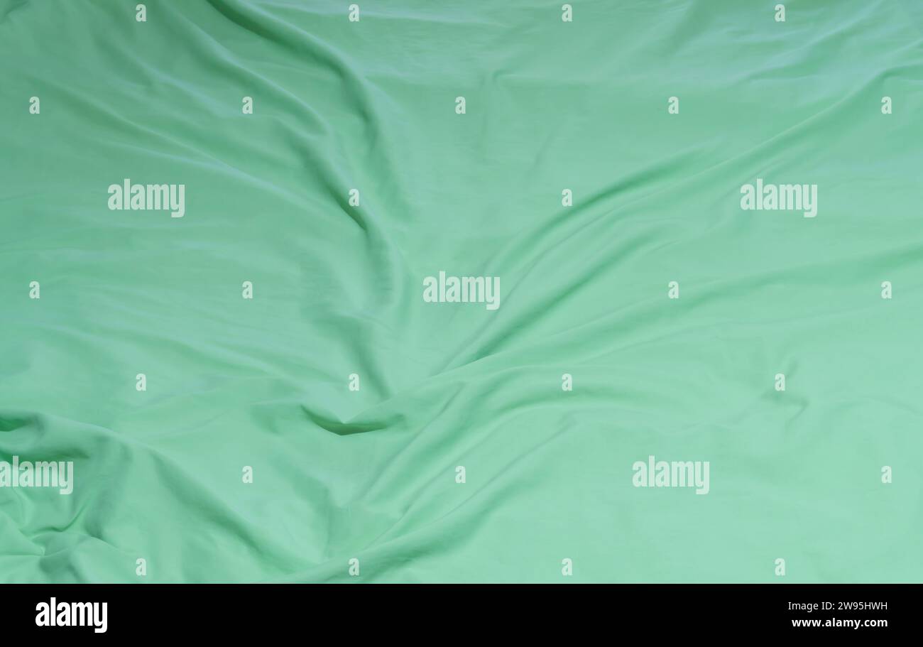 Drap de literie vert froissé ou froissé ou couverture avec motif après utilisation par le client a été pris dans l'hôtel, la chambre de villégiature avec espace de copie. Bac de couverture en désordre Banque D'Images