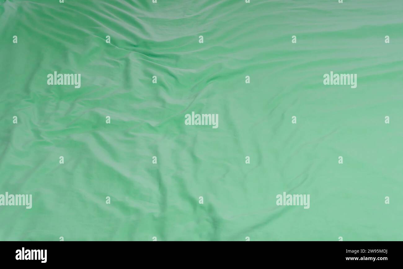 Drap de literie vert froissé ou froissé ou couverture avec motif après utilisation par le client a été pris dans l'hôtel, la chambre de villégiature avec espace de copie. Bac de couverture en désordre Banque D'Images