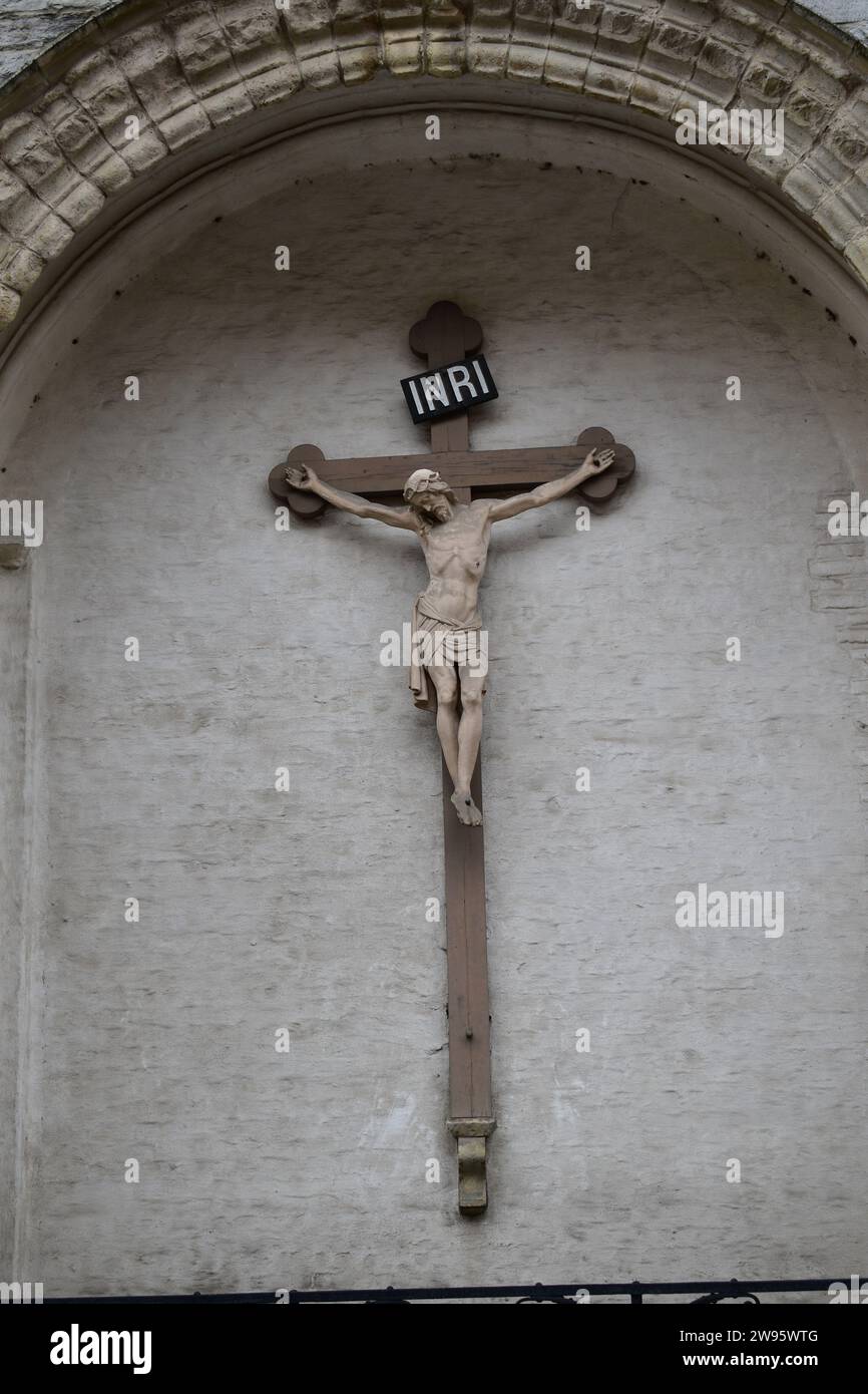 Un Jésus Christ en marbre sur une croix en bois avec les lettres 'INRI' au-dessus de sa tête à l'église notre-Dame de Bruges Banque D'Images