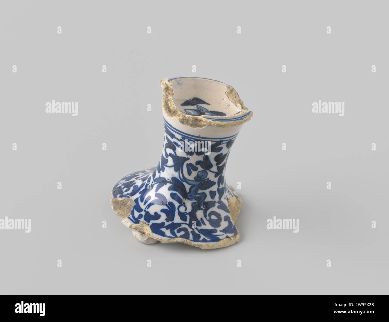 Pointu de faïence blanche -cuisson, sous la forme d'une base verticale décorée de moules de fleurs stylisés en bleu sur une surface blanche, et sur le dessus d'un plat sur lequel deux fruits sont peints en bleu sur blanc, anonyme, c. 1500 - c. 1699 fragment de faïence. glaçage Banque D'Images