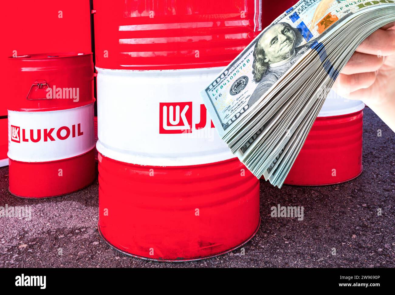 Samara, Russie - 15 septembre 2019 : barils de la compagnie pétrolière Lukoil et dollars américains dans la main Banque D'Images