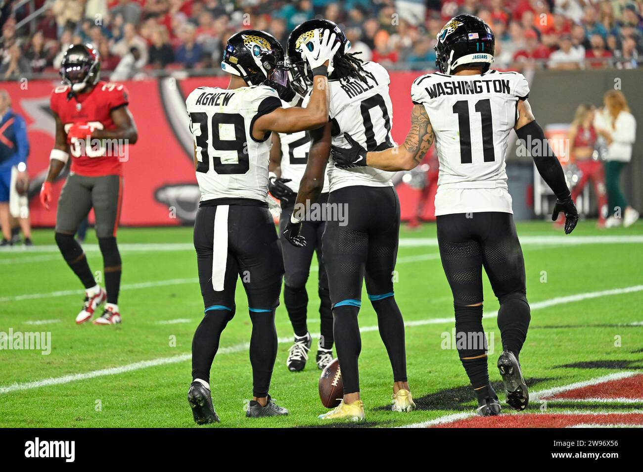 Tampa, États-Unis. 24 décembre 2023. Jamal Agnew (39) des Jaguars de Jacksonville, le Wide Receiver Calvin Ridley (0) et Parker Washington (11) ont battu les Buccaneers de Tampa Bay lors de la seconde mi-temps au Raymond James Stadium de Tampa, en Floride, le dimanche 24 décembre 2023. Photo de Steve Nesius/UPI. Crédit : UPI/Alamy Live News Banque D'Images