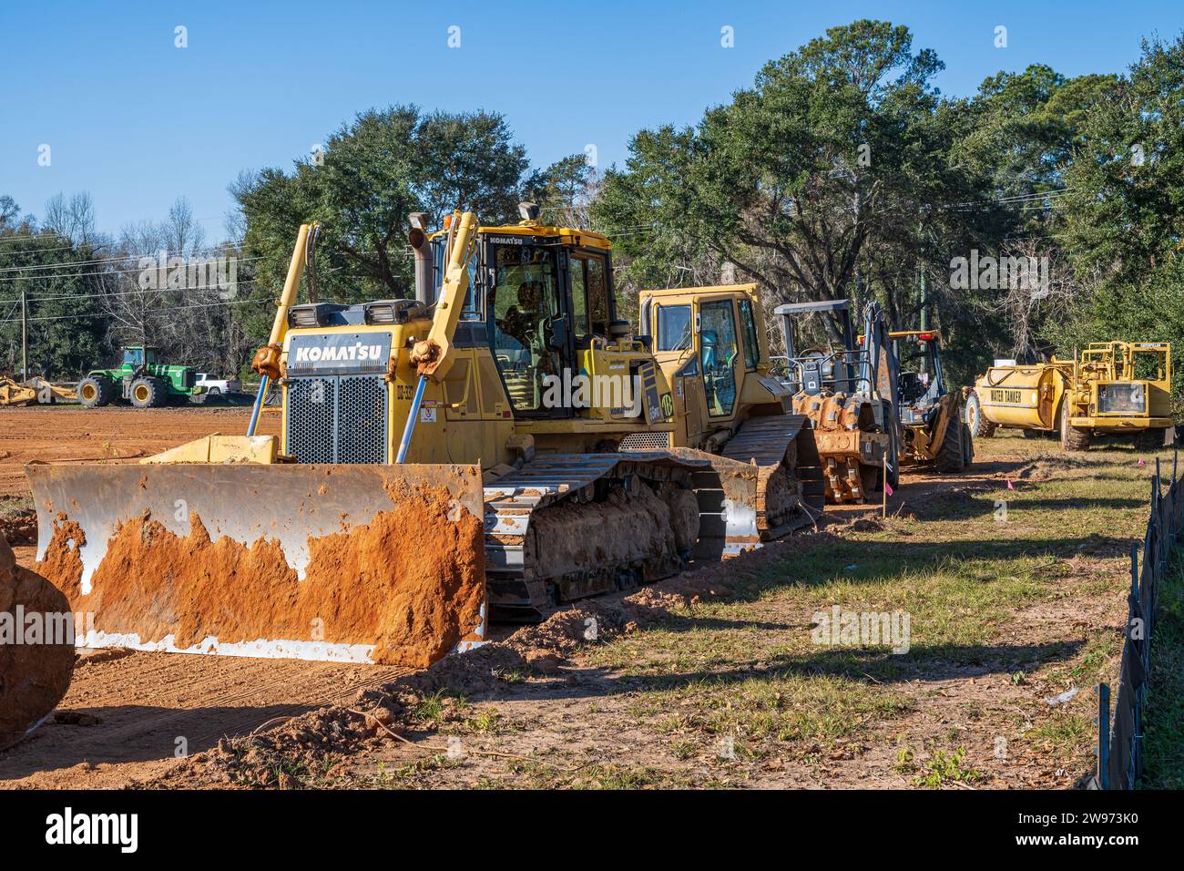 Bulldozer Komatsu 65PXi ou engin de terrassement sur chenilles aligné avec d'autres équipements de construction lourds sur un chantier de construction à Pike Road Alabama USA. Banque D'Images