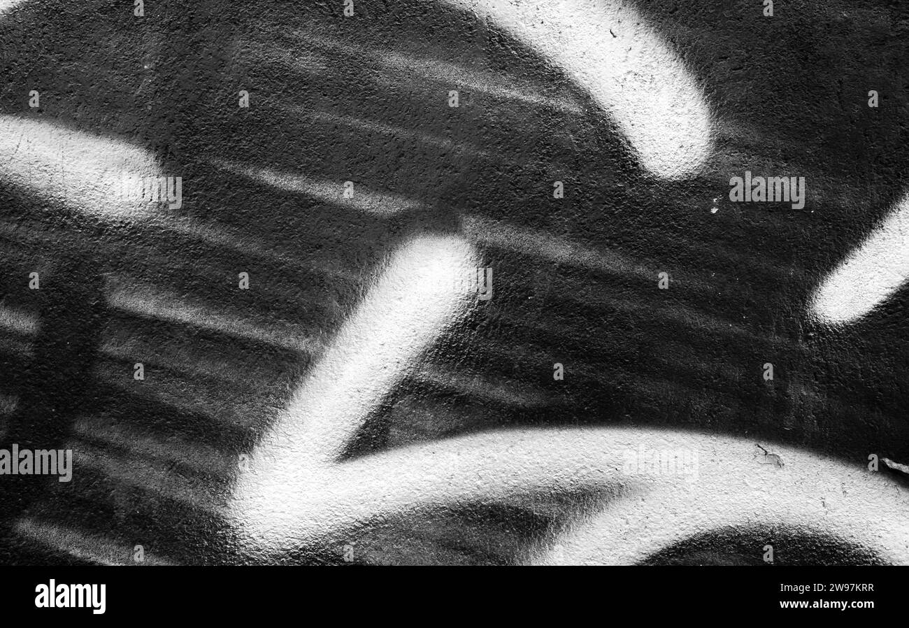 Fragment de graffiti abstrait, mur de béton urbain avec des lignes de peinture, noir et blanc Banque D'Images