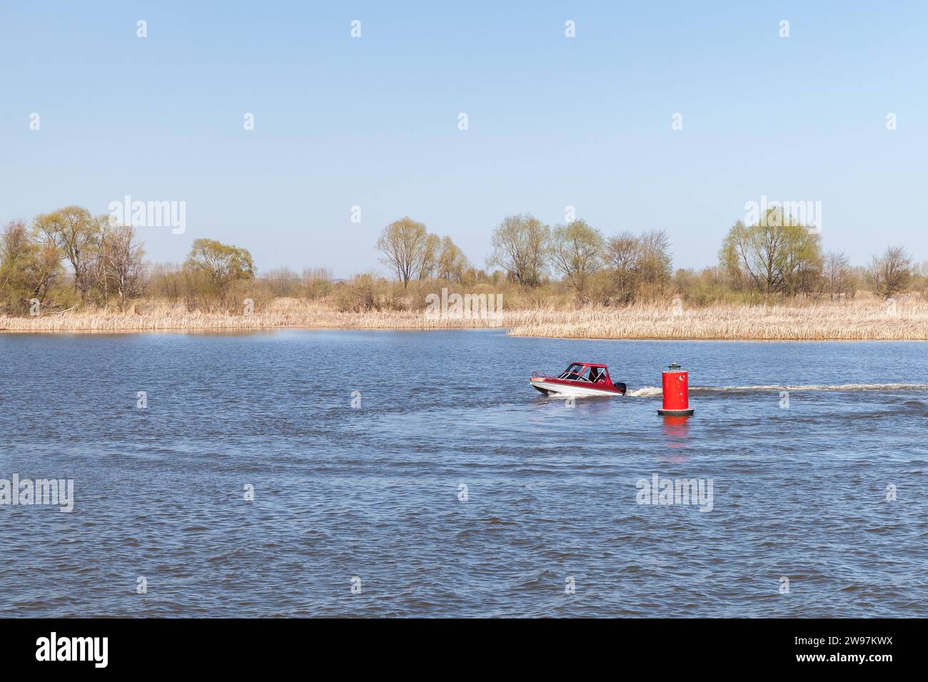 Petit bateau à moteur navigue le fairway de la rivière Volga près de la bouée rouge. Bolgar, Tatarstan, Russie Banque D'Images