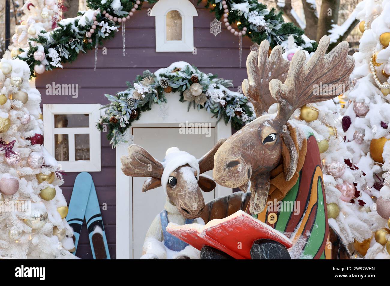 Élan de Noël avec livre sur une rue d'hiver, décorations du nouvel an en ville. Personnages de conte de fées, ambiance de vacances, magie de la célébration Banque D'Images
