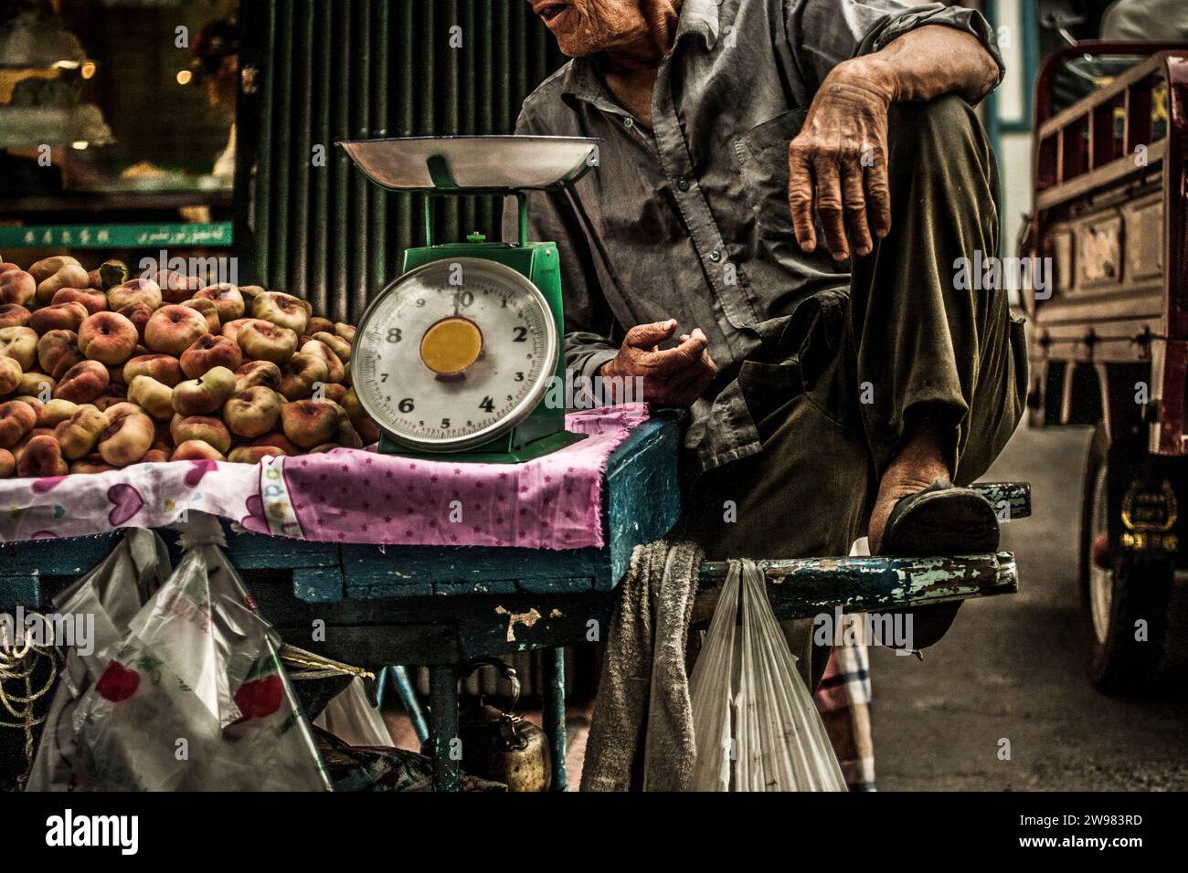 Vendeur de fruits assis sur son chariot. Banque D'Images