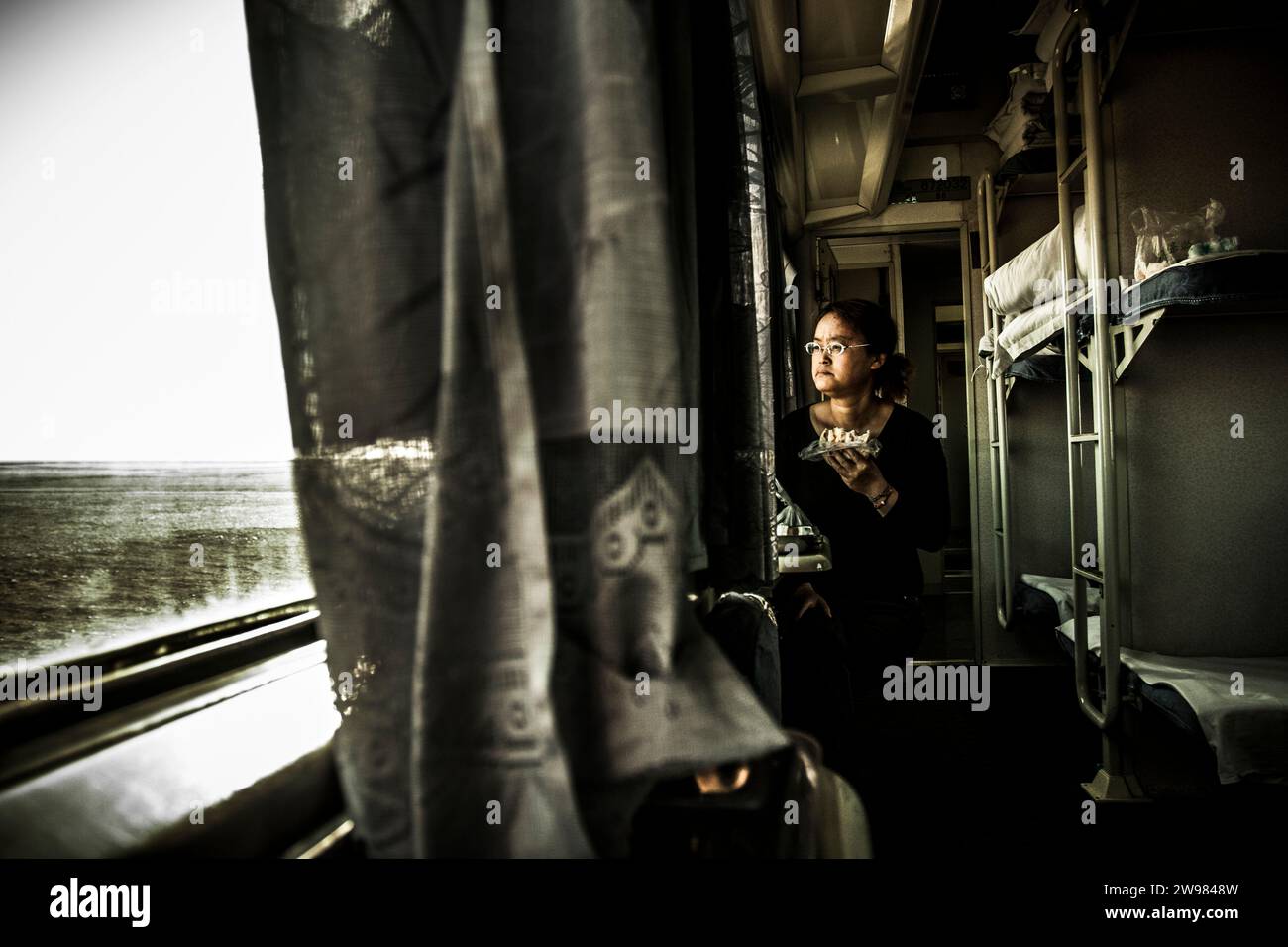 Une chinoise déjeunant dans un train. Banque D'Images