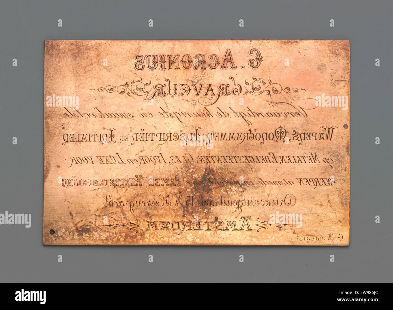 Texte publicitaire, c. 1900 - c. 1930 texte 'G. Acrronius. Graveur. Fait les armes les plus belles et les plus savoureuses, monogrammes, inscriptions et initiales sur les métaux, les pierres précieuses, le verre, l'ivoire et les articles de luxe ainsi que mis en place pour l'estampage papier-couleur. Amsterdam.' gravure sur cuivre (métal) Banque D'Images
