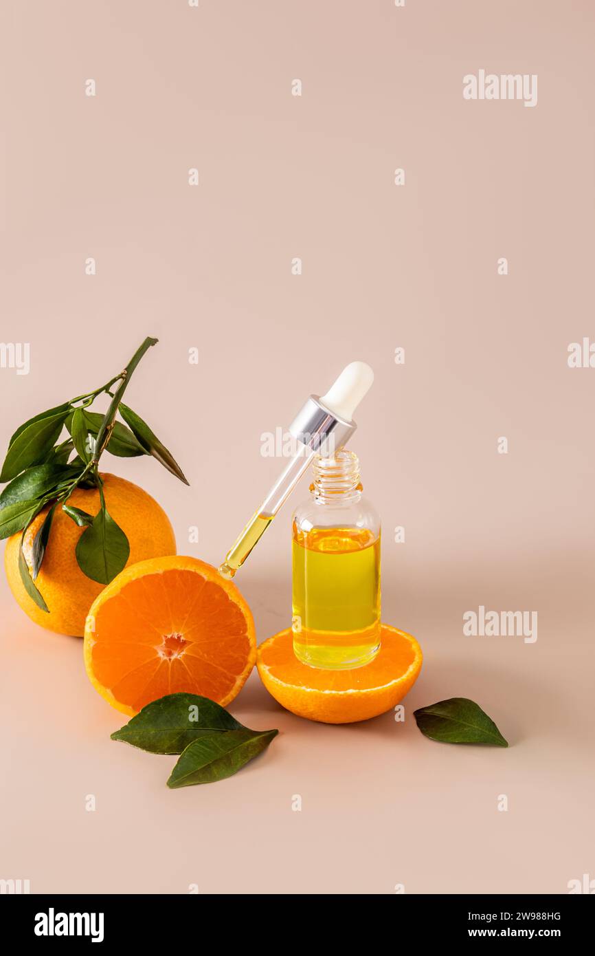 L'invention concerne un flacon ouvert contenant un produit cosmétique pour les soins de la peau du visage et du corps et une pipette remplie de ce produit contre des mandarines fraîches. sérum hydratant Banque D'Images