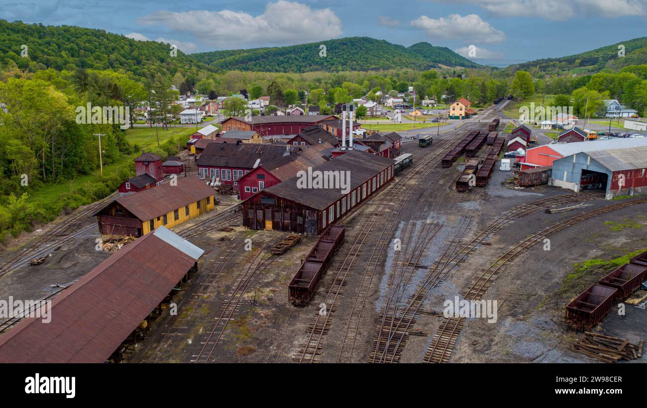 Une vue aérienne d'un triage de train à voie étroite, avec des trémies à charbon, des magasins et une rotonde, par un jour de printemps ensoleillé Banque D'Images