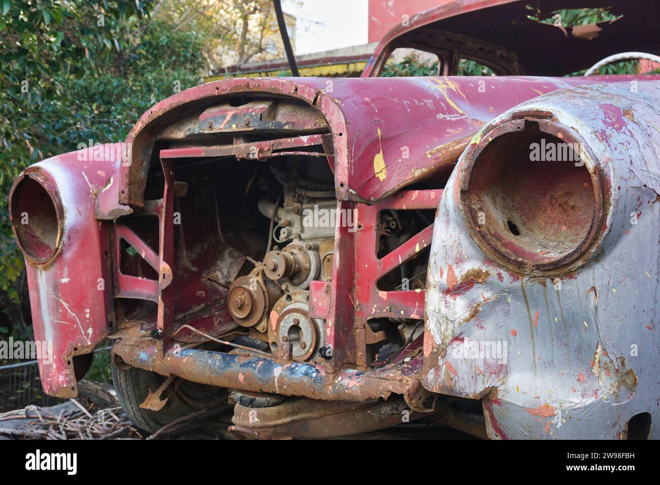 Partie avant de la vieille voiture rouge classique abandonnée avec moteur exposé Banque D'Images