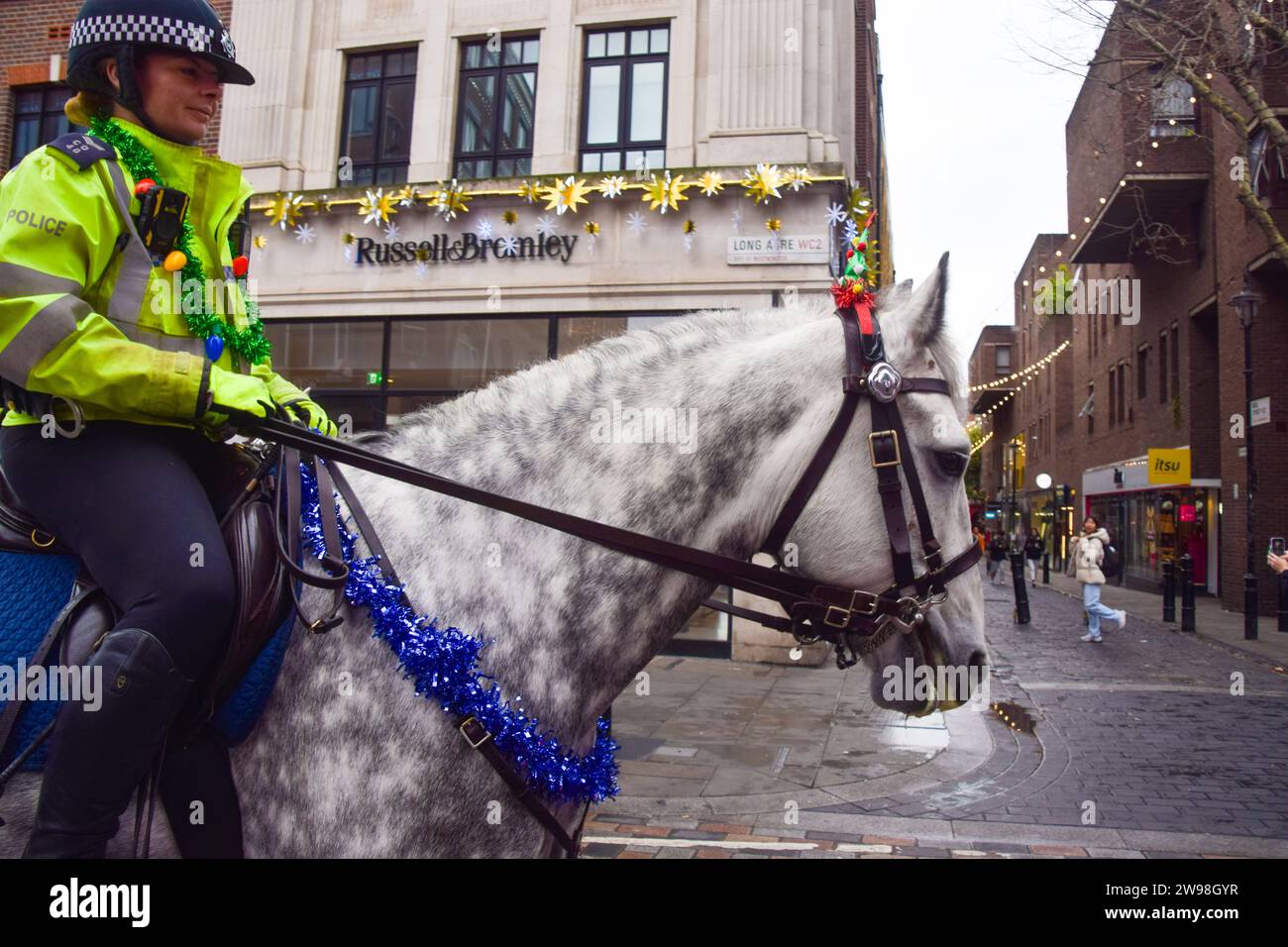 Londres, Royaume-Uni. 25 décembre 2023. Un cheval de police porte des décorations festives à Covent Garden par un jour de Noël exceptionnellement doux. Les températures douces, atteignant 13 degrés Celsius dans la capitale, suivent la veille de Noël la plus chaude depuis plus de 20 ans. Crédit : Vuk Valcic/Alamy Live News Banque D'Images