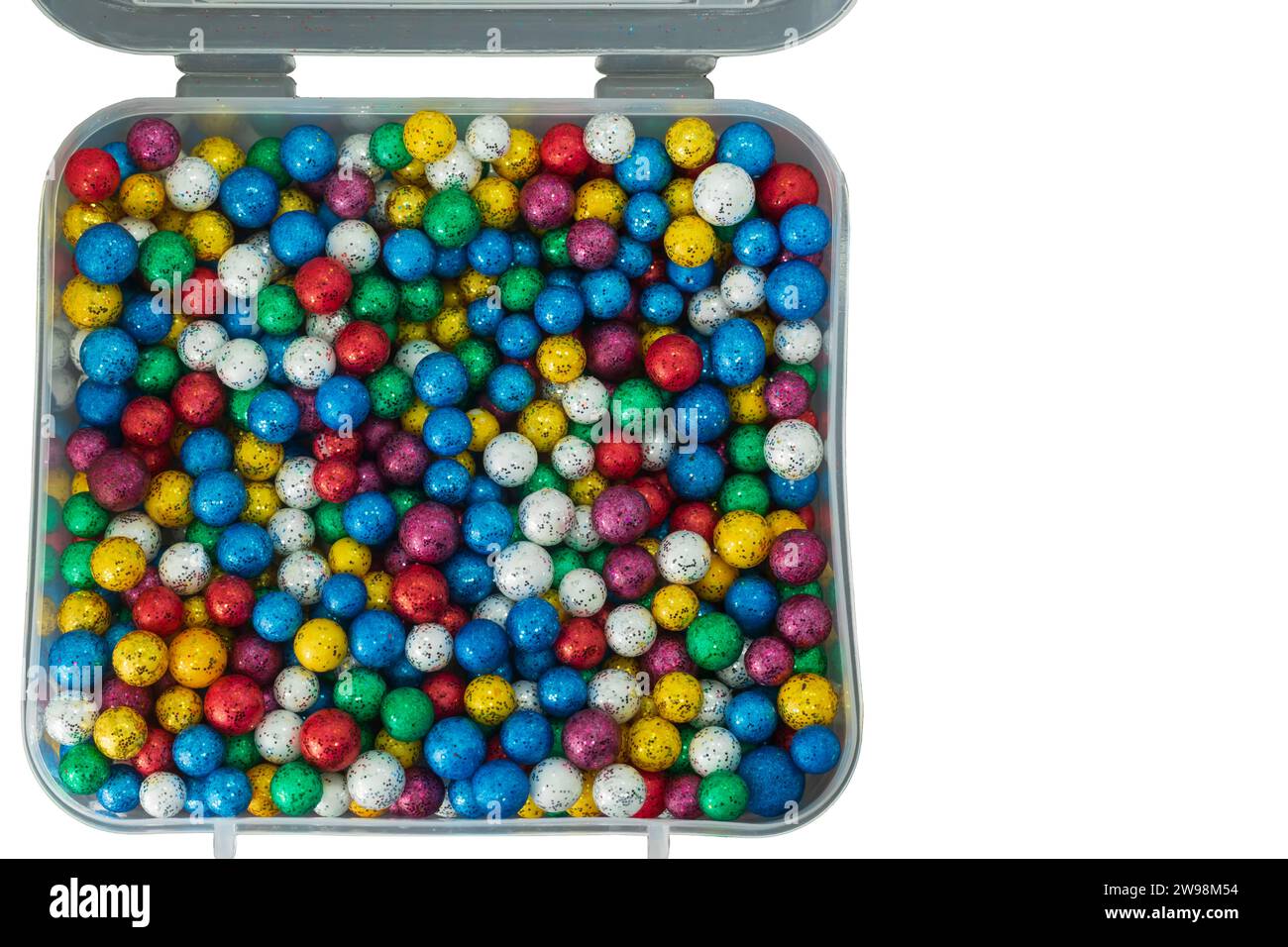Une pile de petites boules colorées en thermocol dans une boîte en plastique isolée sur un fond blanc. Banque D'Images