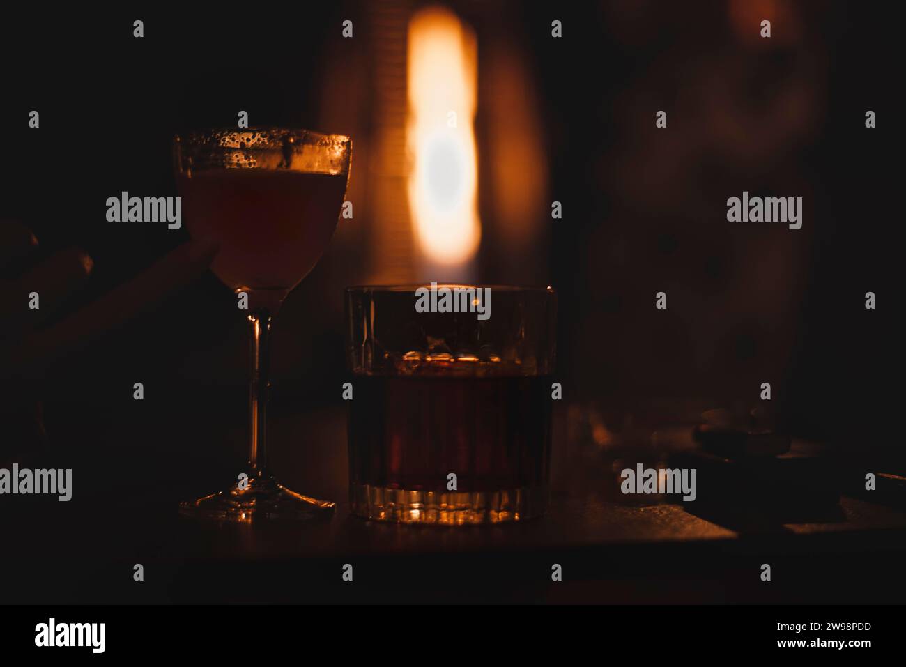 Image d'un verre avec un cocktail dans un bar de nuit sur le fond d'un chauffage enflammé. Concept de restaurant Banque D'Images