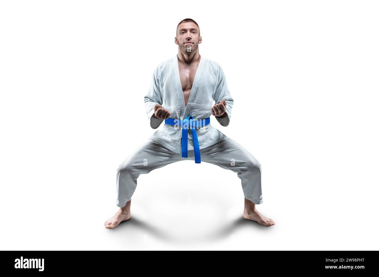 Athlète en kimono avec une ceinture bleue se tient en position de combat. Concept de karaté, sambo, jujitsu. Supports mixtes Banque D'Images