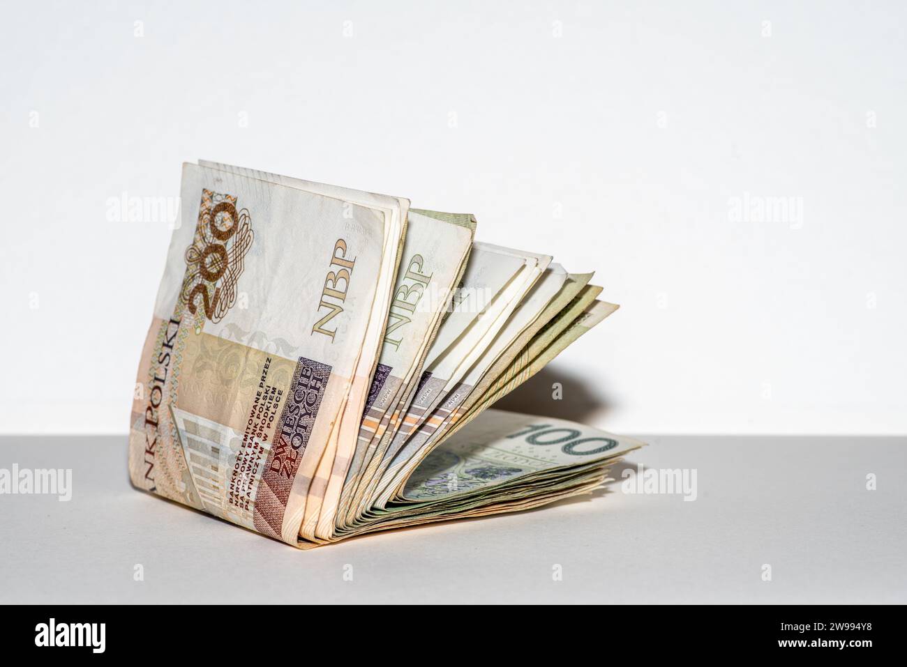 Une pile de notes zloty polonaises sur fond blanc Uni Banque D'Images
