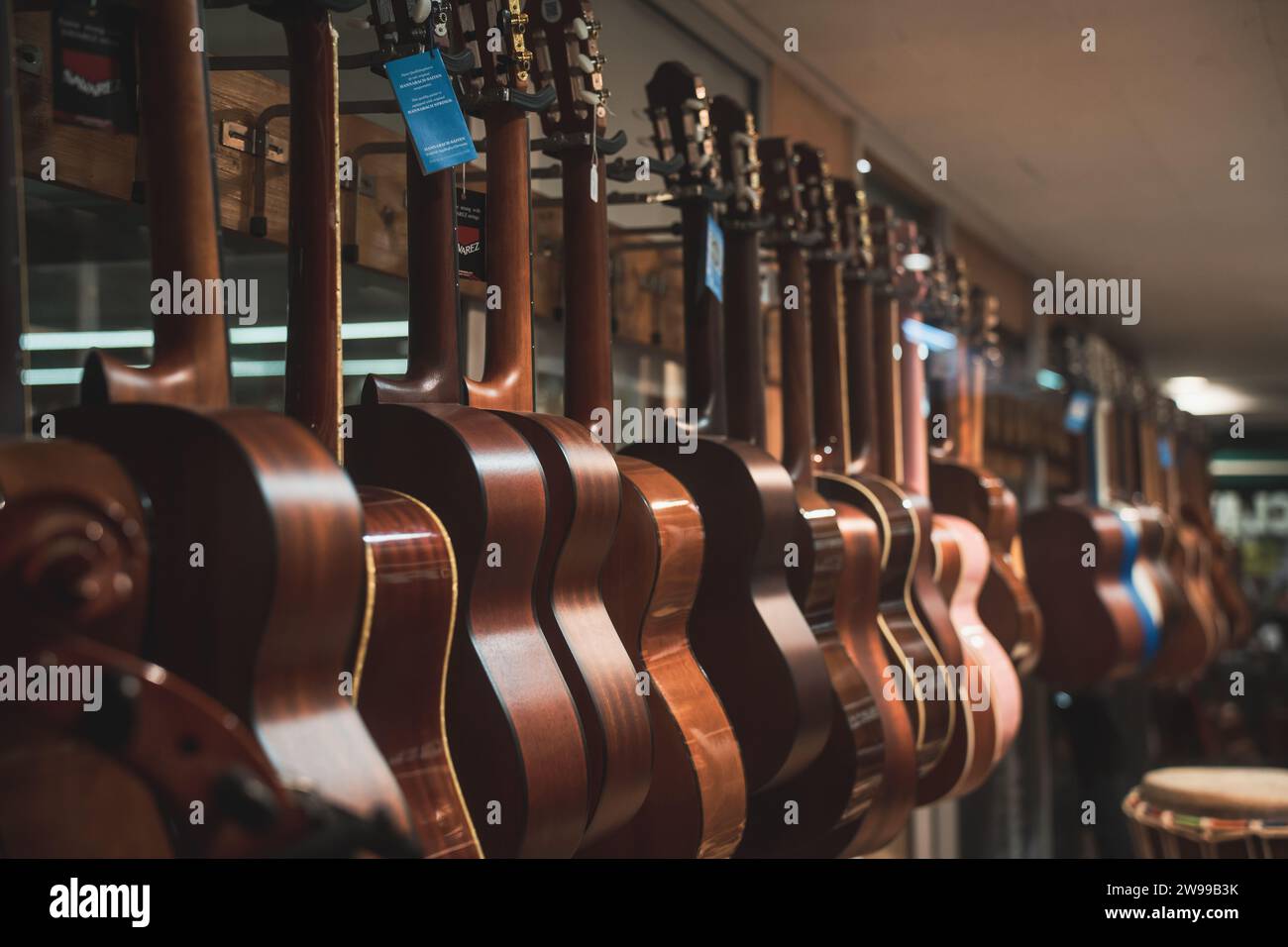 Image d'un magasin de musique avec plusieurs instruments de guitare suspendus à des cordes Banque D'Images