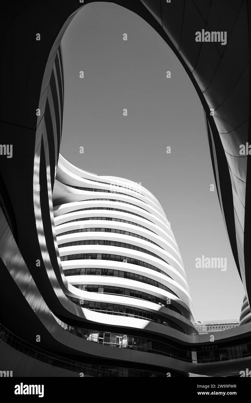 Une photographie artistique en noir et blanc d'un immeuble de bureaux contemporain avec un design incurvé unique Banque D'Images