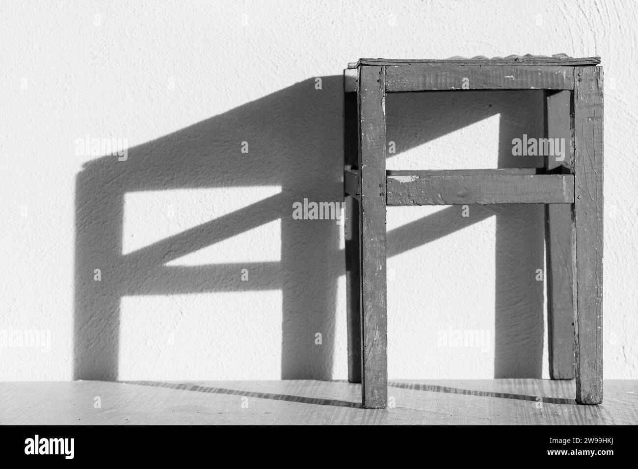 Éclairage de chaise sur le fond de mur blanc. Lumière et ombre. Noir et blanc, Monochrome. Banque D'Images